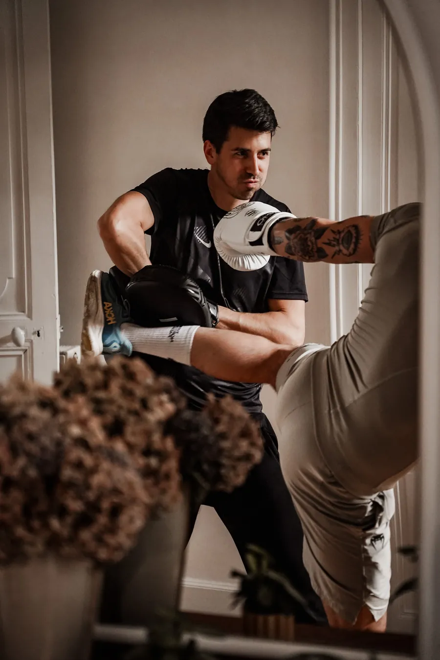 Coup de pied dans une patte d'ours tenue par le coach, inspiré du taekwondo, pendant une séance à domicile