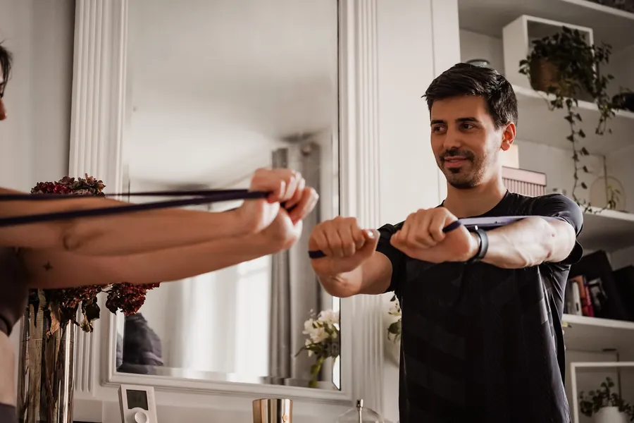 Renforcement des épaules et du haut du dos avec un élastique, démontré par le coach