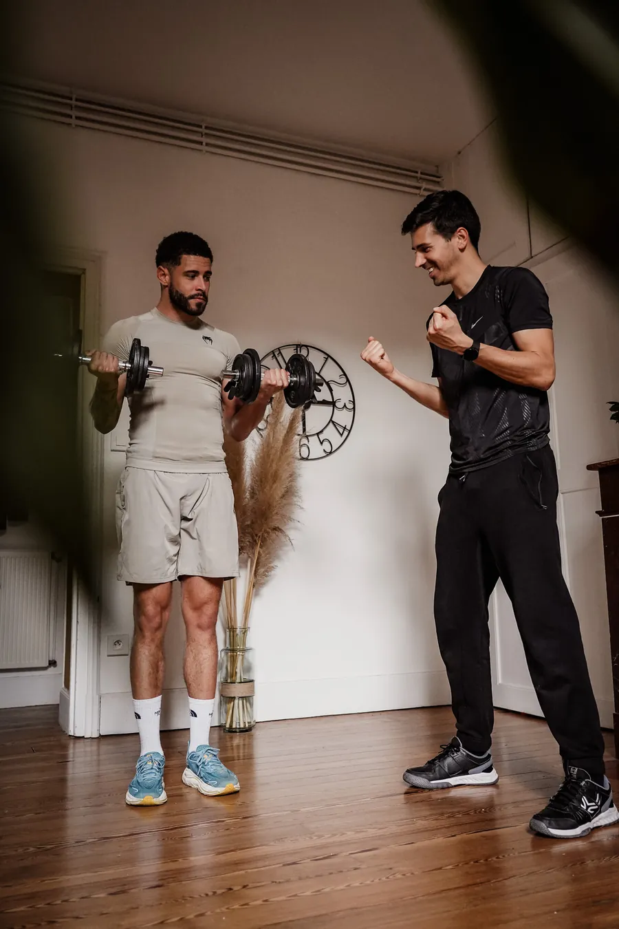 Séance de renforcement musculaire avec haltères à domicile, encouragée par le coach